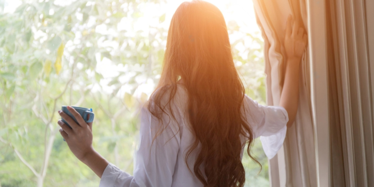 Imagen de mujer mirando por la ventana climalit